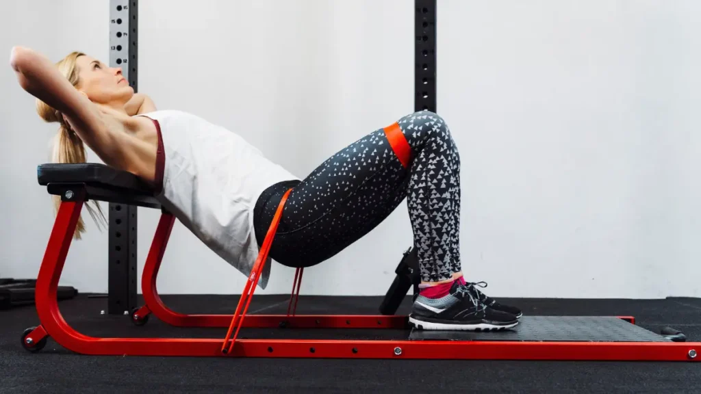 Mulher fazendo hip thrust com faixa elástica para glúteos