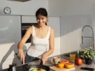 Mulher preparando café da manhã saudável em cozinha moderna durante rotina de jejum intermitente