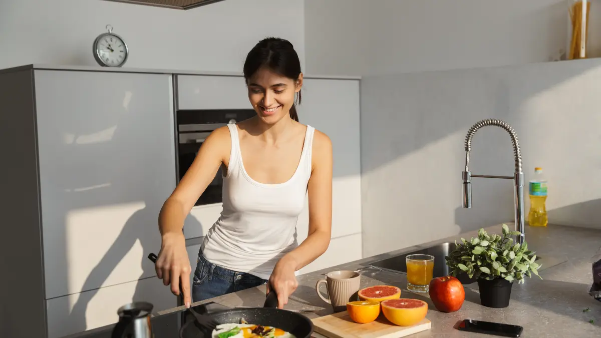Mulher preparando café da manhã saudável em cozinha moderna durante rotina de jejum intermitente