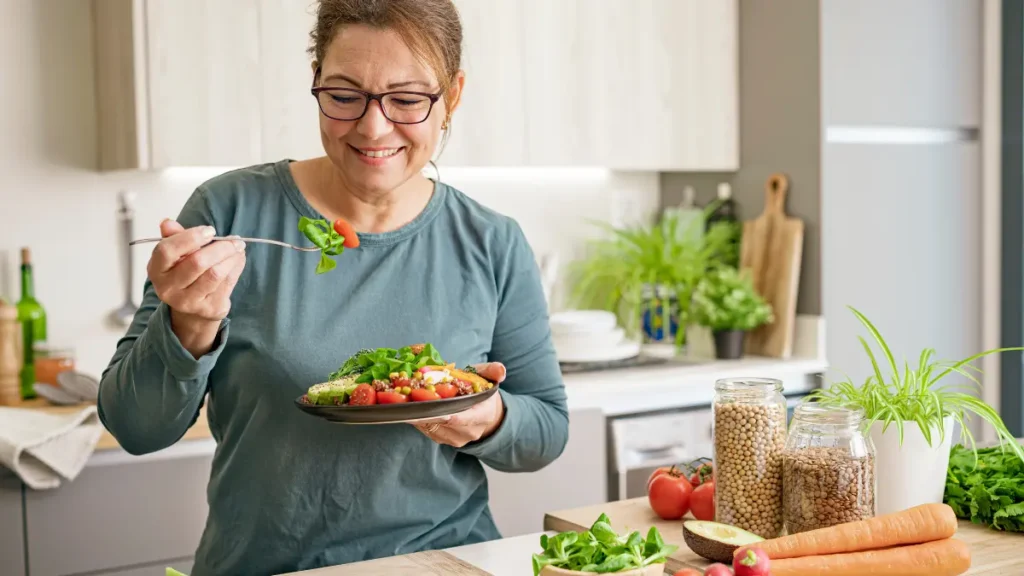 Jejum Intermitente para Mulheres: Benefícios e Cuidados Essenciais 2 Mulher consumindo refeição saudável rica em vegetais durante janela alimentar do jejum intermitente