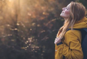 Mulher relaxando durante caminhada ao ar livre para aliviar estresse e ansiedade