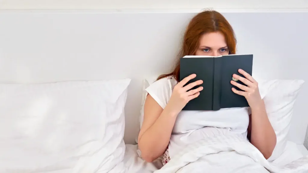 Mulher lendo um livro antes de dormir como parte de uma rotina saudável de sono