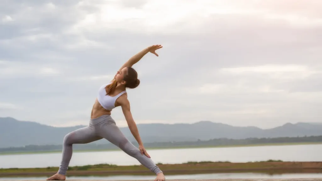 Mulher praticando yoga ao ar livre para reduzir estresse e ansiedade