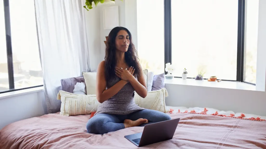 Mulher praticando meditação em casa para reduzir o estresse e melhorar o humor