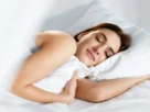 Mulher dormindo tranquilamente para melhorar recuperação muscular e desempenho nos treinos